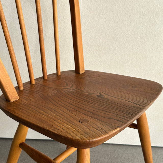 Mid-century British vintage teak Ercol hoop back dining chair with smooth grain seat and slender spindle legs.