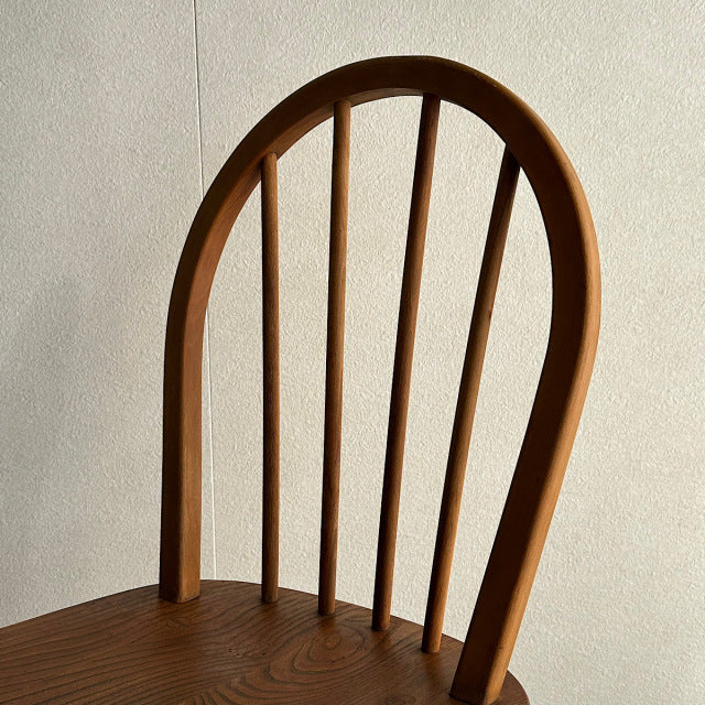 Mid-century British vintage teak Ercol hoop-back chair with curved spindles and visible wood grain.
