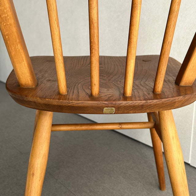 Mid-century British vintage Arcol hoop-back chair in teak with smooth wood grain and rounded legs.