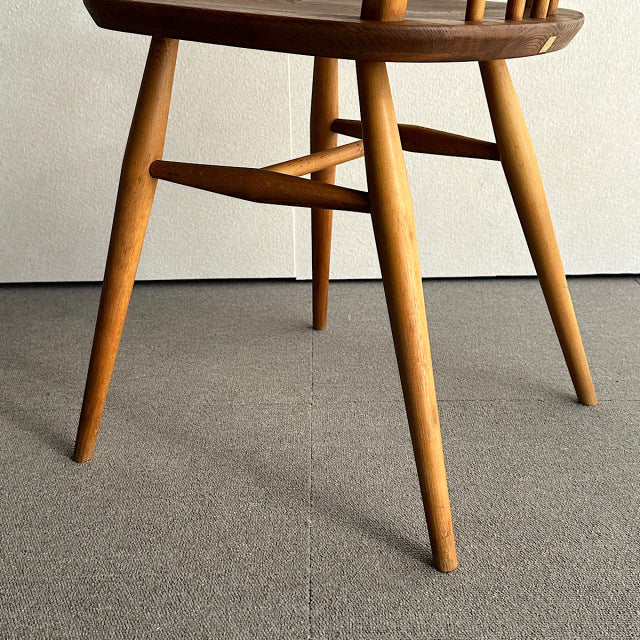 Vintage teak mid-century British Ercol Hoop Back Chair with slender tapered legs and smooth wood grain.