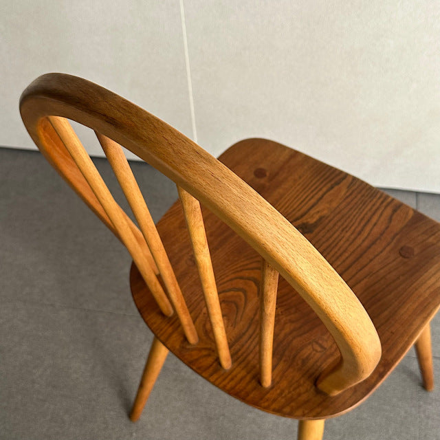 Vintage mid-century British Ercol hoop back chair in warm teak wood with elegant curved backrest and slender vertical.