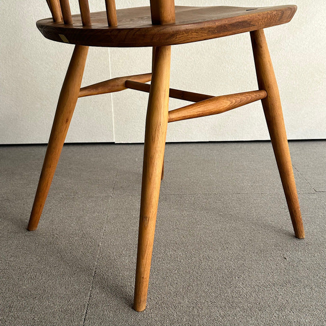 Vintage British mid-century Ercol teak hoop back dining chair with tapered legs and spindle details.