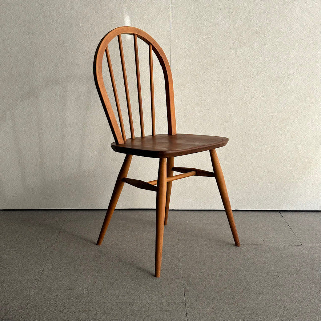 Vintage British Ercol mid-century teak hoop back dining chair with four slender spindles and tapered legs.
