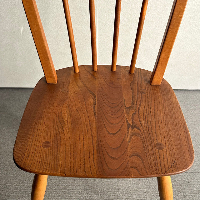 Mid-century British vintage Ercol teak hoop-back dining chair with visible wood grain and four slender vertical spindles.