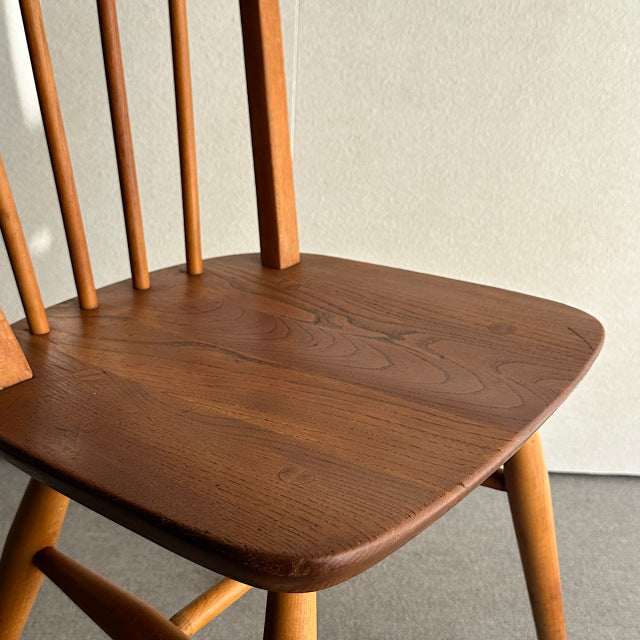 Vintage British mid-century ERCOL teak hoop-back dining chair seat and spindle backrest detail.