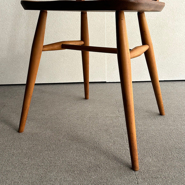 Mid-century British vintage Ercol hoop-back chair legs in warm teak with visible wood grain and tapered design.