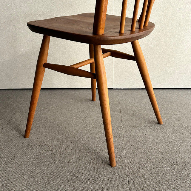 Mid-century British vintage Ercol hoop back chair in warm teak with spindle back and tapered legs.