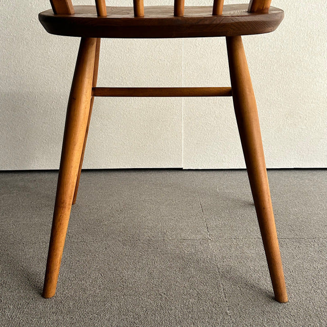 Mid-century British vintage Ercol hoop back chair in rich teak with smooth wood grain and tapered legs.