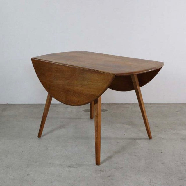 Mid-century British vintage Ercol drop-leaf dining table in teak with rounded edges and tapered legs.