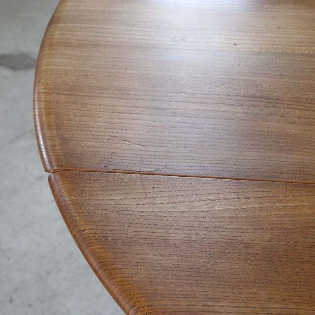 Vintage British mid-century Arcol dining table in teak wood with smooth grain and rounded edge drop-leaf design.