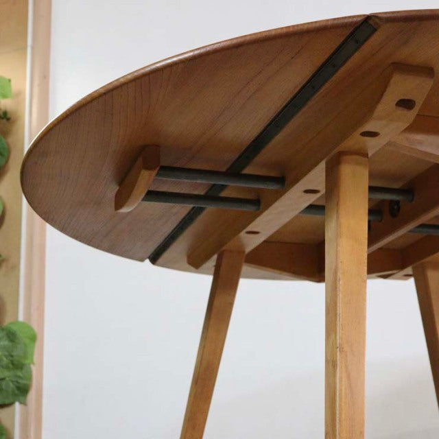 Mid-century British vintage Ercol drop-leaf dining table in teak with smooth grain and sturdy angled legs.
