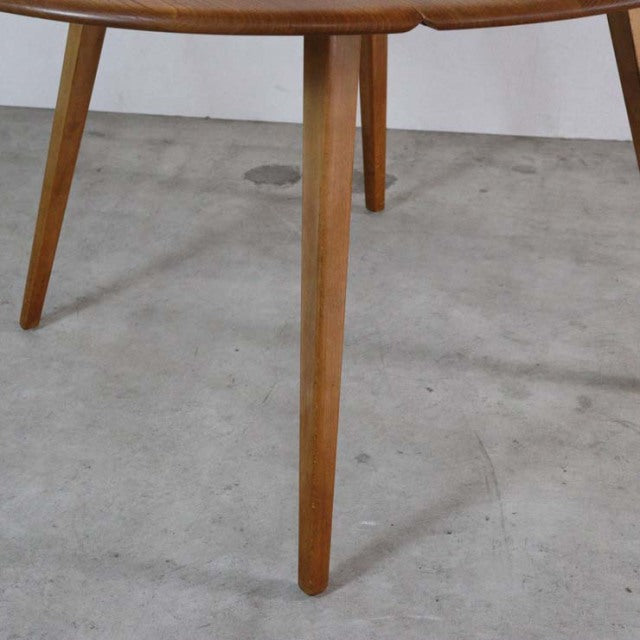 Mid-century British vintage teak dining table with tapered legs and visible wood grain in Danish style.