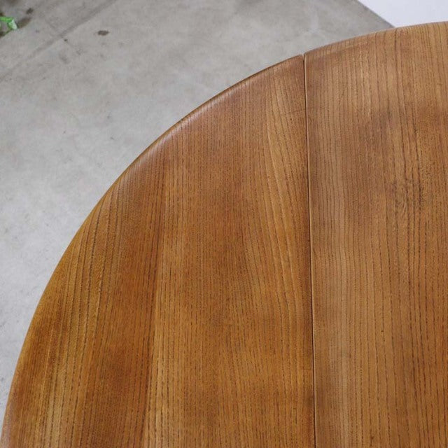 Mid-century British vintage Ercol dining table in teak with smooth wood grain and rounded drop-leaf edge.