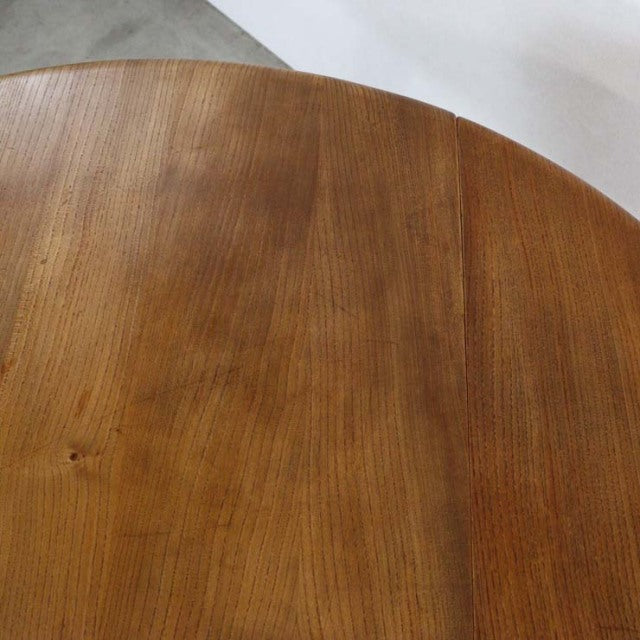 Vintage British mid-century teak drop-leaf dining table with rich wood grain and rounded edges.