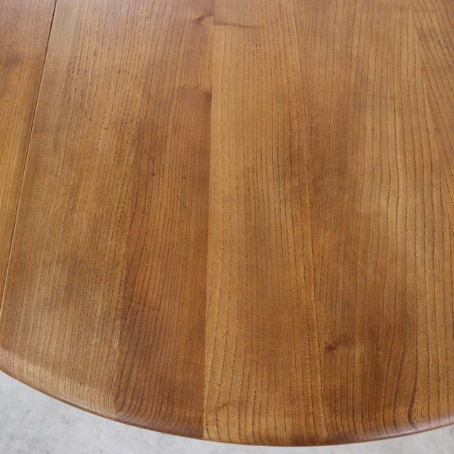 Vintage British Ercol mid-century teak dining table with smooth rounded edge and rich wood grain.