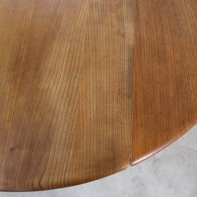Vintage British mid-century teak dining table with smooth rounded edge and visible wood grain.
