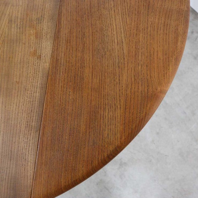 Vintage mid-century British Ercol dining table drop-leaf top in rich teak with visible wood grain and smooth rounded edges.