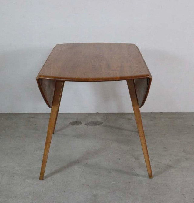 Mid-century British vintage Ercol teak dining table with drop-leaf design, tapered legs, and smooth wood grain.