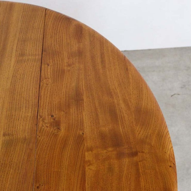 Vintage British mid-century Ercol dining table in teak with smooth grain and rounded drop-leaf edge.