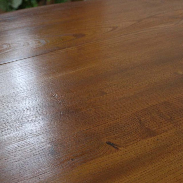 Close-up of British mid-century vintage Ercol dining table surface in warm teak with visible wood grain and natural patina.