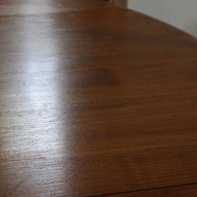 Vintage British mid-century Ercol dining table in rich teak with smooth grain and drop-leaf edge.