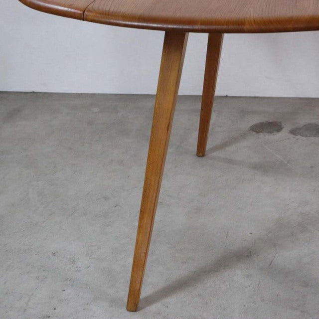 Mid-century British Arcol vintage teak dining table leg with tapered design and rich wood grain on concrete floor.