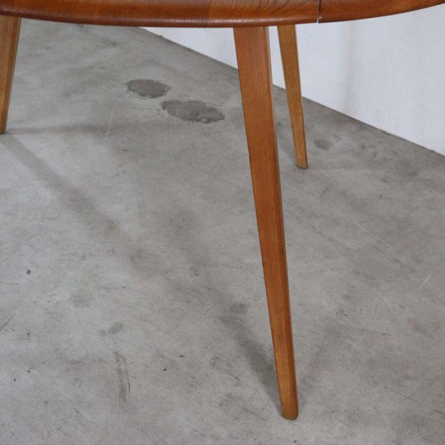 Mid-century British vintage Ercol dining table in teak with tapered legs and smooth wood grain finish.