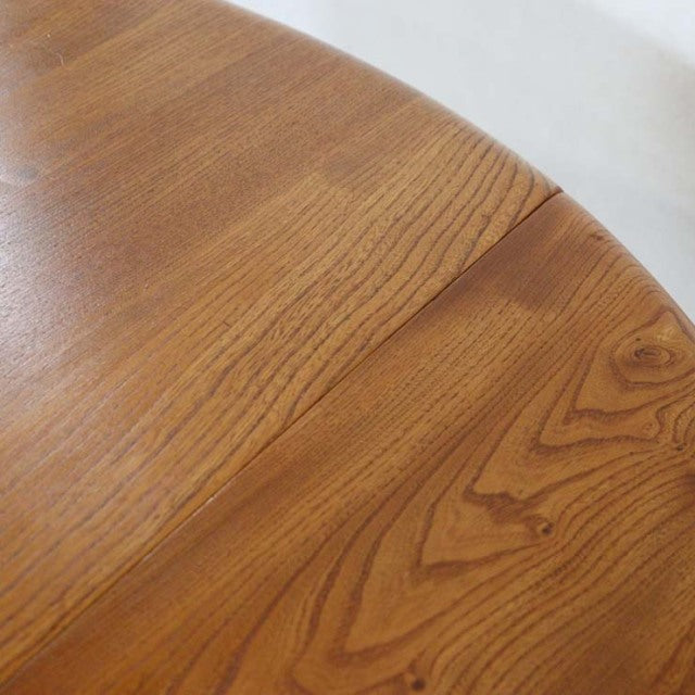 Close-up of vintage British teak dining table top showing rich wood grain and smooth mid-century finish.