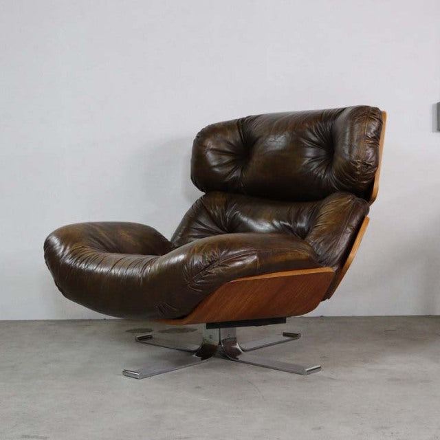 Vintage mid-century leather lounge chair with tufted dark brown upholstery, teak wood frame, and star-shaped metal swivel.