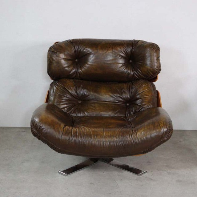 Vintage mid-century British leather armchair with deep button tufting, rich brown leather upholstery, and polished teak wood .