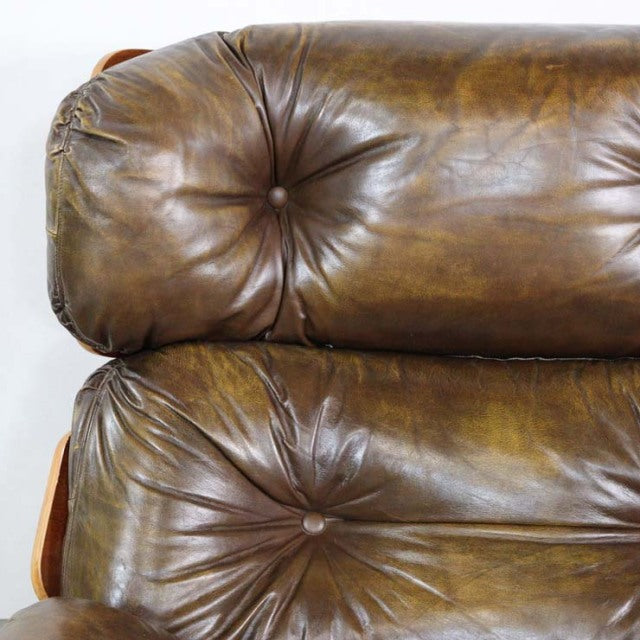 Vintage mid-century British leather armchair with rich brown teak frame and deep button tufting.