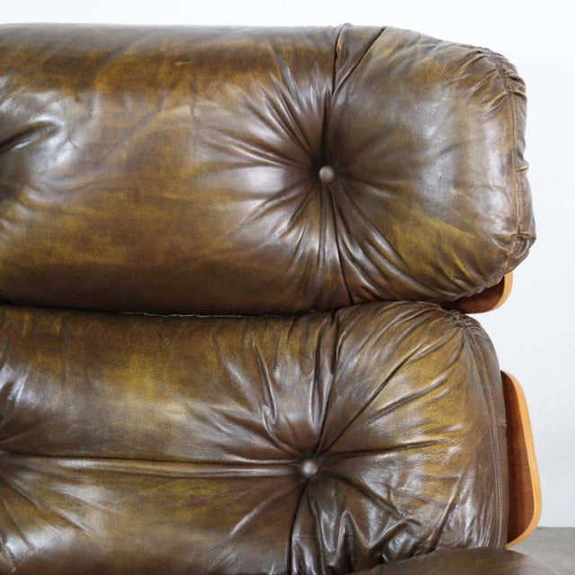 Vintage mid-century British teak leather sofa backrest with deep button tufting and natural wood grain.