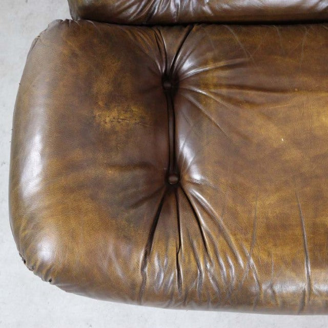 Vintage mid-century British leather armchair seat in rich brown, tufted cushion, natural wear and patina on textured surface.
