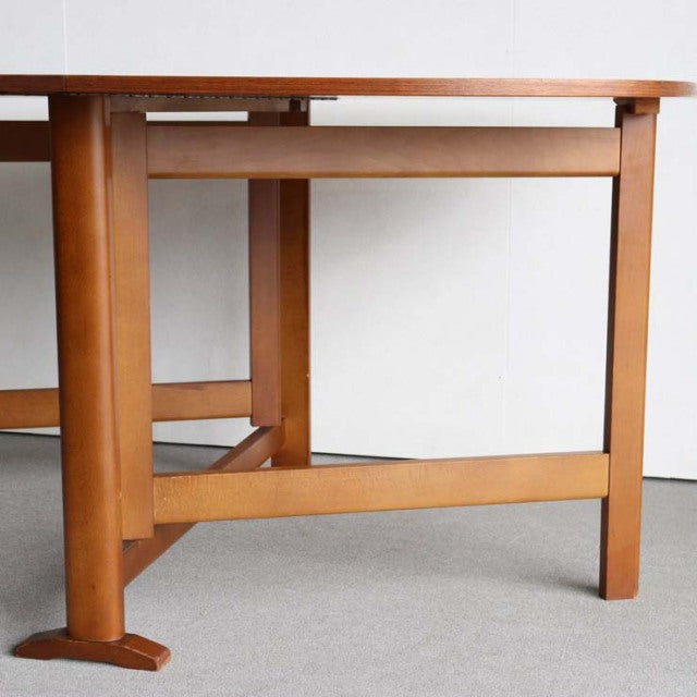 Vintage teak dining table with mid-century British-Denmark design, showcasing rich wood grain and sturdy square legs with.