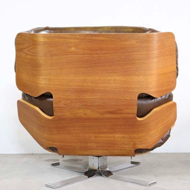 Vintage mid-century leather armchair with curved teak wood shell and polished metal swivel base, British-Denmark design.