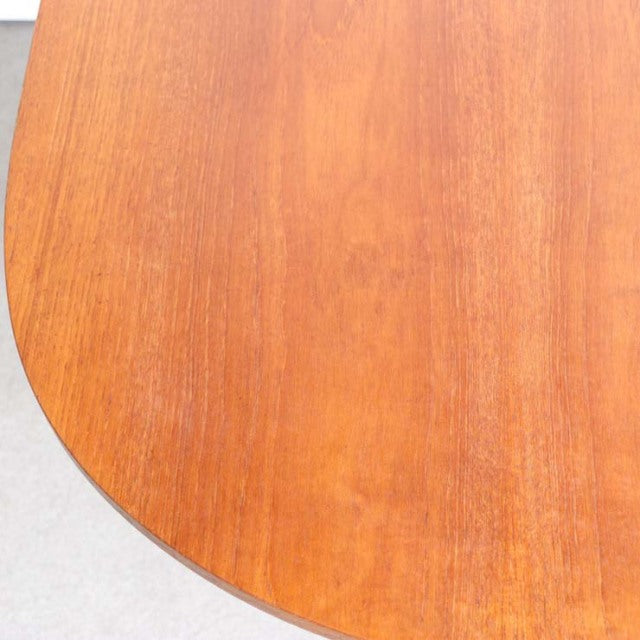 Vintage mid-century teak dining table top showing warm wood grain and smooth rounded edge, British-Denmark design.