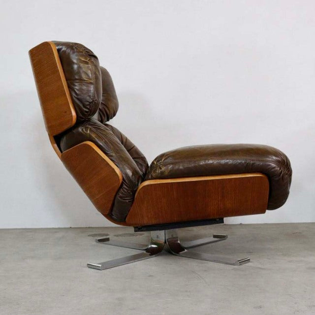 Vintage mid-century British leather lounge chair with teak wood frame, deep button tufting, and metal swivel base.