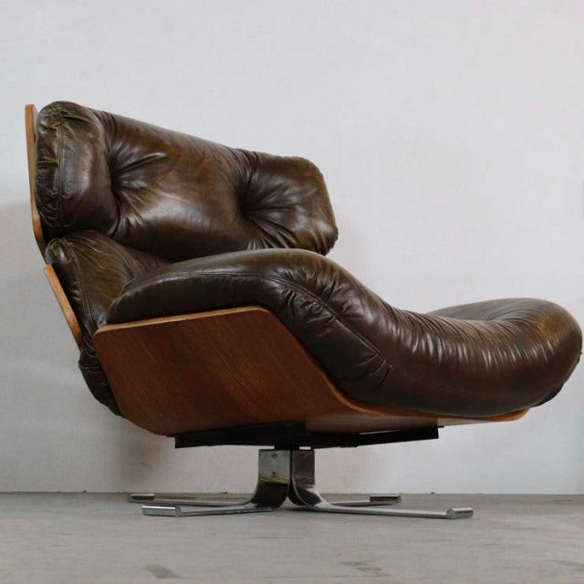 Mid-century British vintage leather lounge chair with rich brown leather cushions, teak wood frame showcasing warm wood.