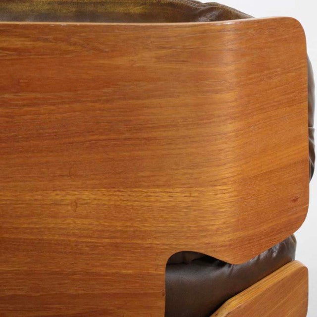 Mid-century teak wood panel with smooth grain and rounded edges on British vintage leather armchair from Denmark.
