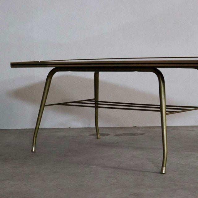 Mid-century British teak coffee table with sleek rounded edges, slender angled legs, and lower slatted shelf.