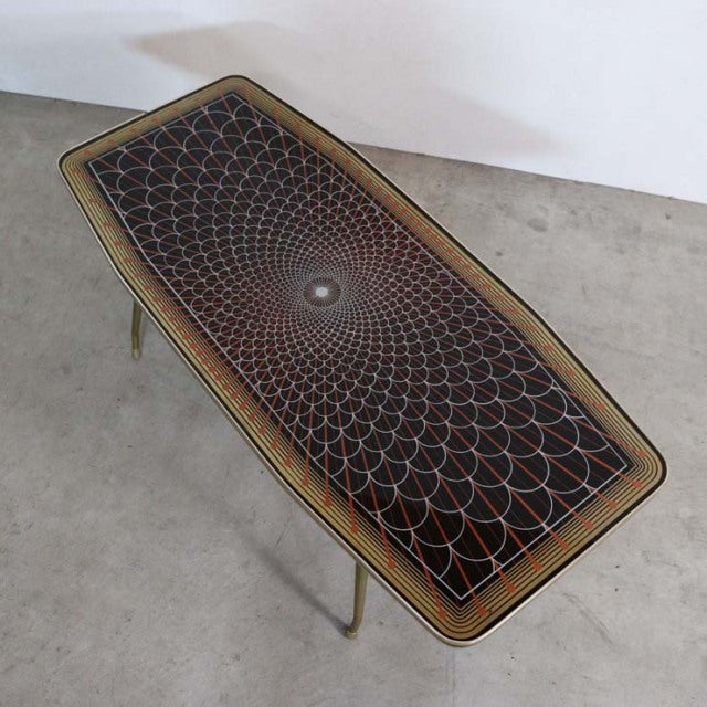 Mid-century British teak coffee table with intricate geometric patterned top and slender tapered legs.