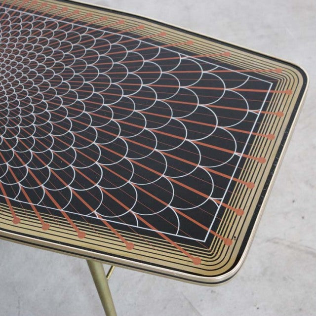 Mid-century British vintage teak coffee table with intricate geometric patterned top and slender angled legs.