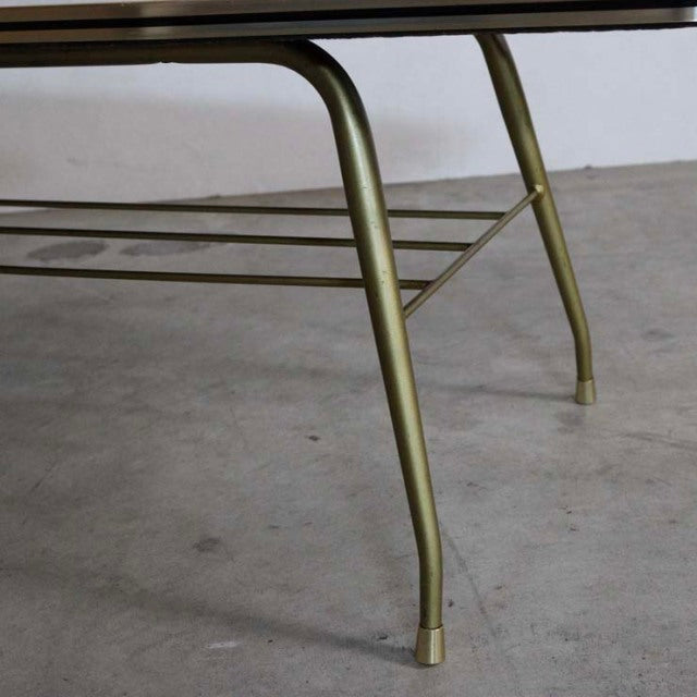 Mid-century teak coffee table with vintage British design, featuring slender brass legs and lower metal rack.