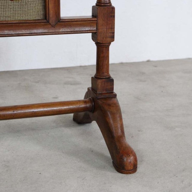 Mid-century British vintage teak fire screen leg with turned wood details and rich wood grain finish on concrete floor.