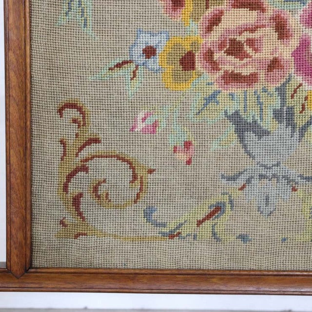 Mid-century British vintage teak fire screen featuring detailed floral tapestry with muted red, yellow, and blue flowers and .