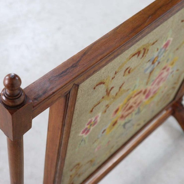 Vintage teak British mid-century fire screen with detailed wood grain and turned finial on corner post, floral tapestry.