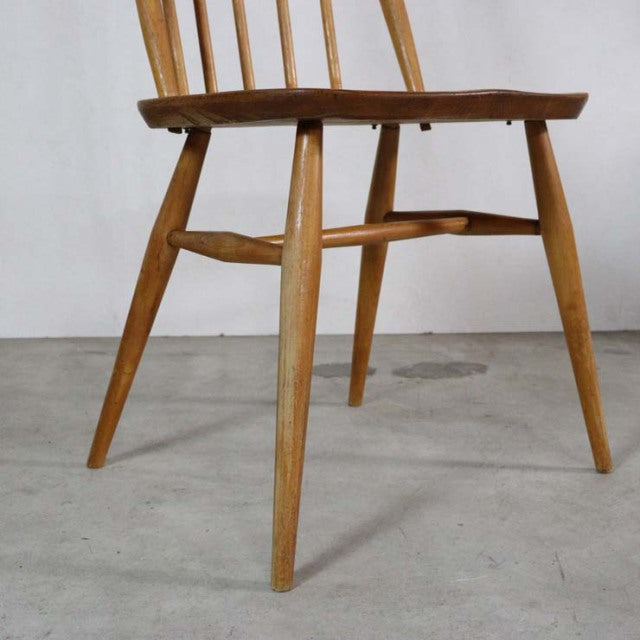 Mid-century British vintage Ercol Quaker dining chair in teak with slender angled legs and spindle back.