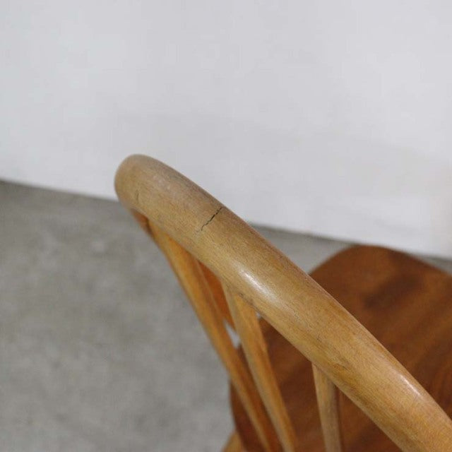 Vintage mid-century British Ercol Quaker chair in teak with curved spindle back and smooth wood grain finish.