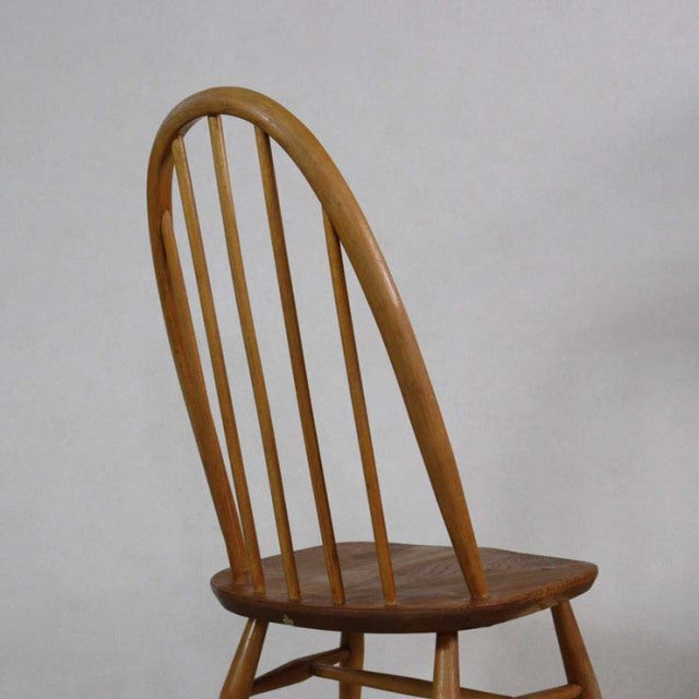 Vintage teak mid-century Ercol Quaker chair with curved backrest and slender vertical spindles, British design.