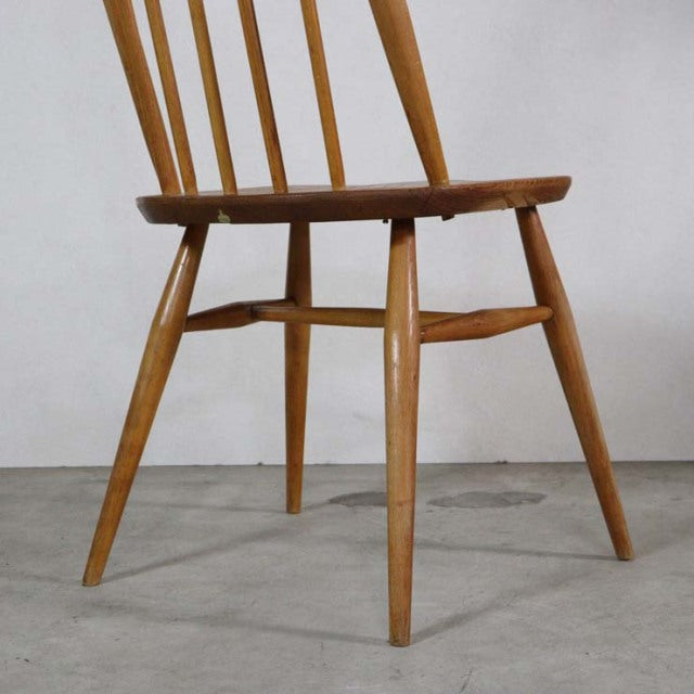 Mid-century British vintage Ercol dining chair in teak with spindle back and slender tapered legs.